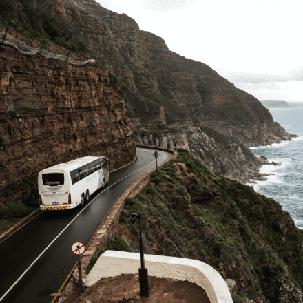 bus driving along road on a scenic cliffside | Special Journeys | Vacations for People with Disabilities