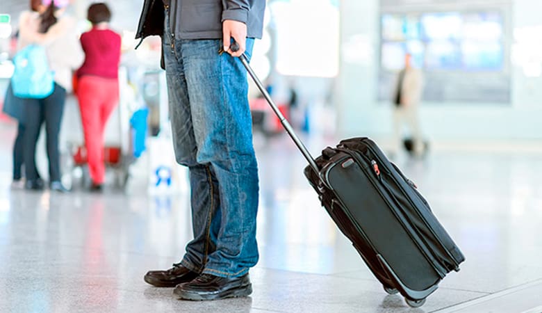 Man with carry-on suitcase at airport