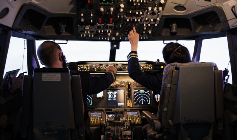 aptain and woman copilot getting ready to fly airplane and takeoff with dashboard navigation in cockpit command. Airline crew fixing altitude level and with control panel buttons, flying plane.