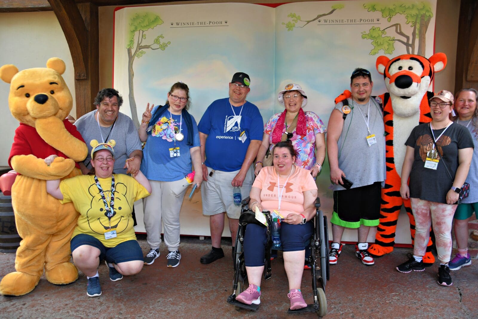 Group of tourists posing with Winnie the Pooh & Tigger | Special Journeys | Wheelchair & Autism Friendly Vacations